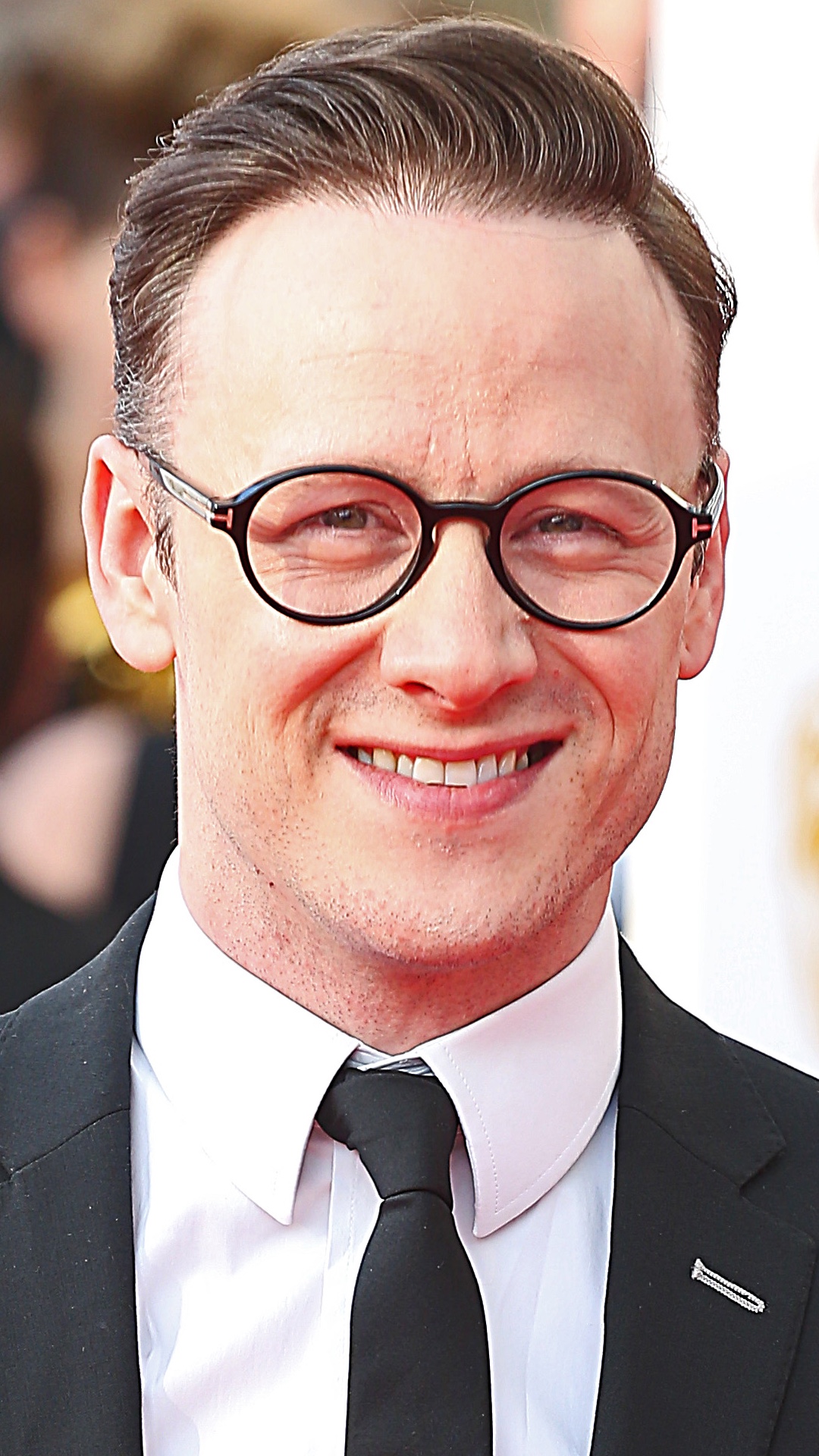 Kevin Clifton smiling and wearing glasses