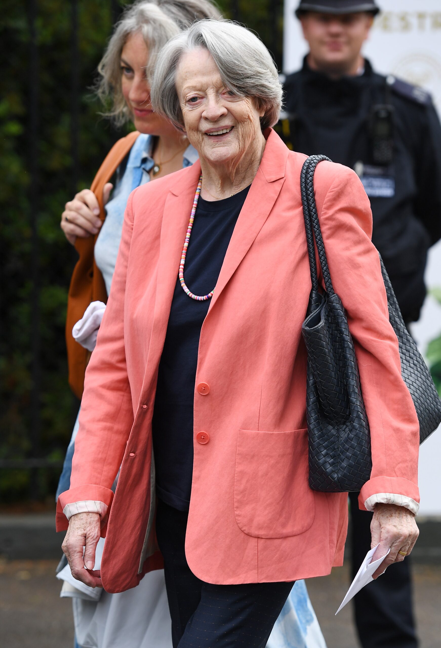 Maggie Smith smiling in pink blazer
