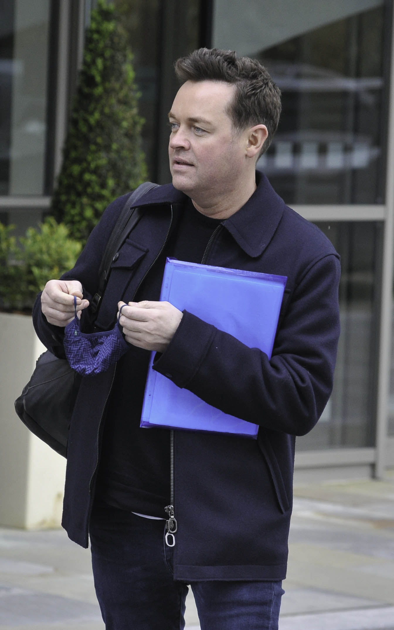 Stephen Mulhern looking stern holding a folder