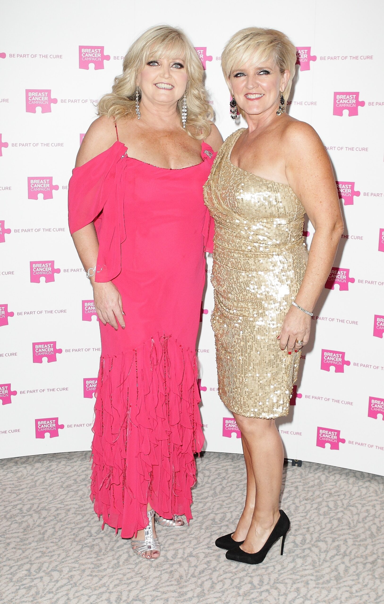 Linda Nolan in a pink dress smiling with her sister Bernie