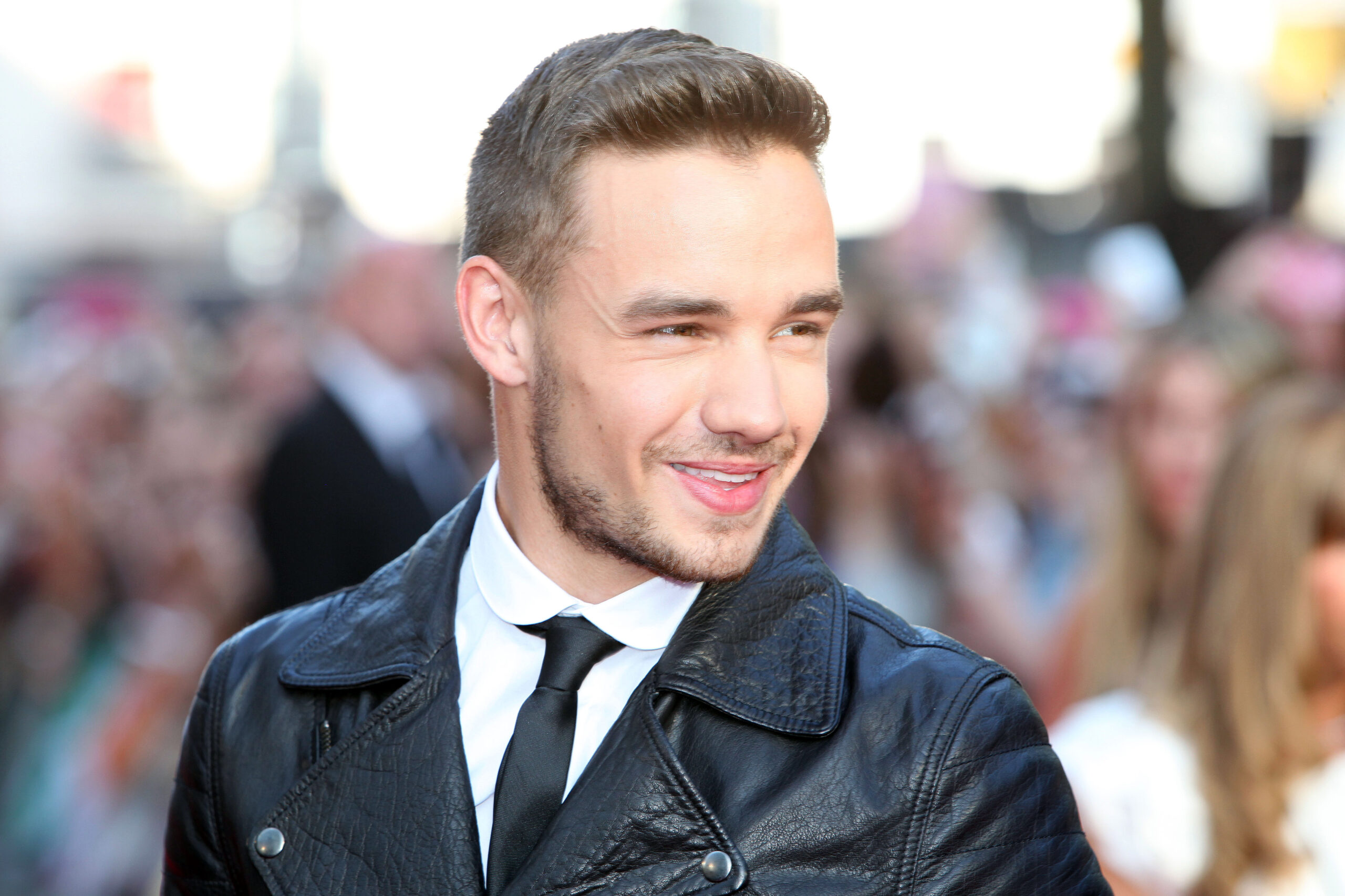 Liam Payne smiling in a leather jacket