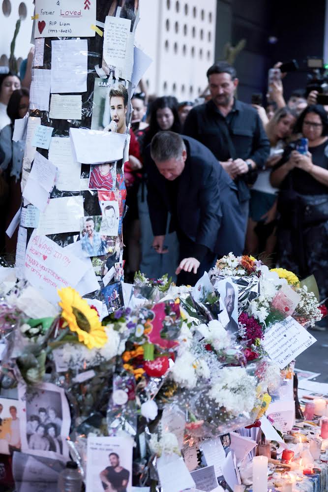 Liam Payne's dad looking at flowers outside htoel