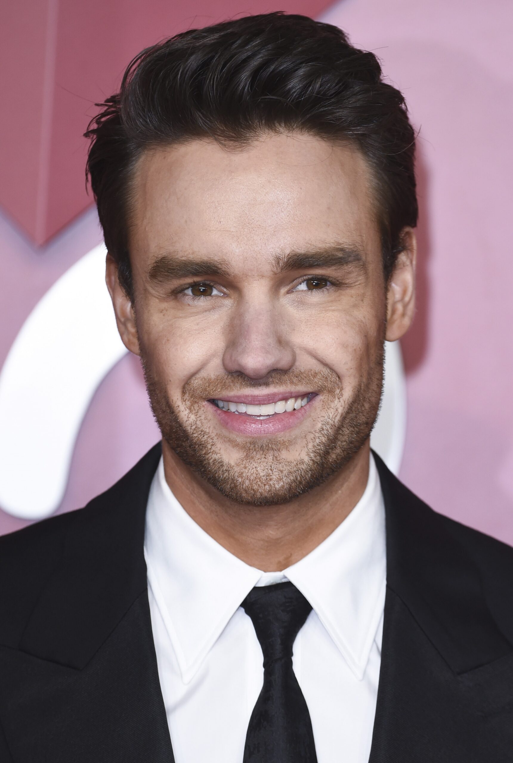 Liam Payne smiling in suit at event