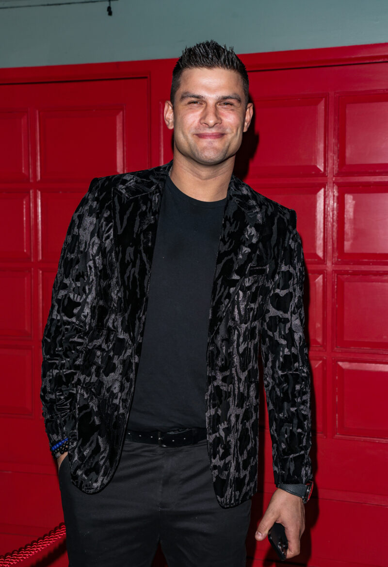 Aljaz Skorjanec standing against a red panelled wall