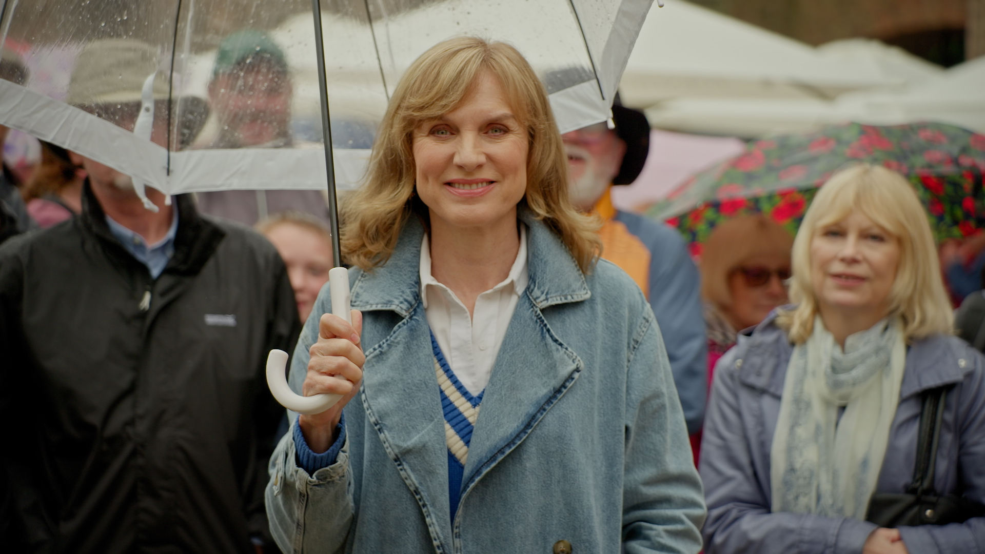 Fiona Bruce standing under an umbrella