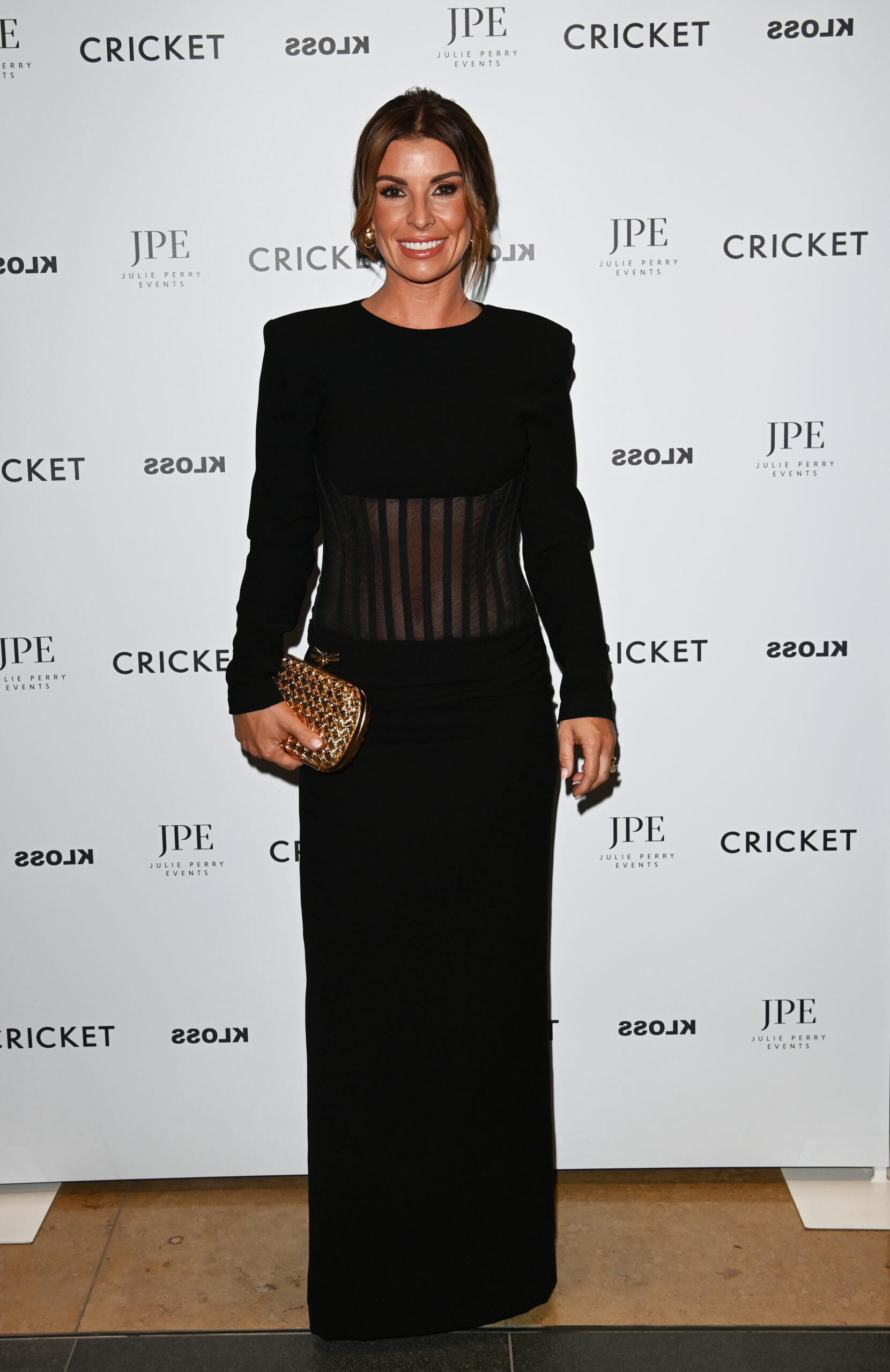 Coleen Rooney smiling at a press event 