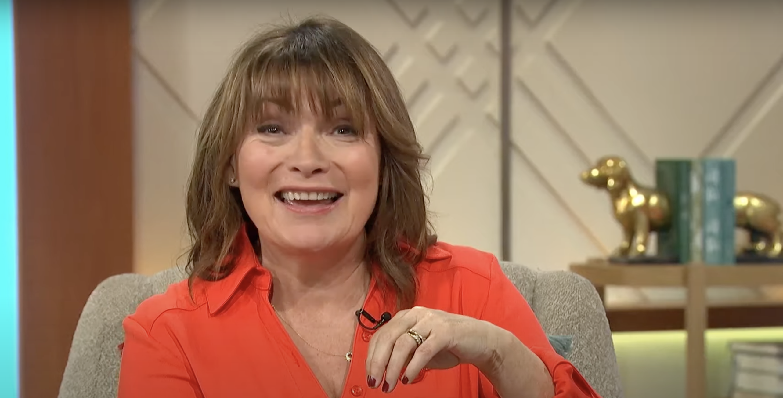 Lorraine Kelly smiling while speaking to a guest on the set of Lorraine