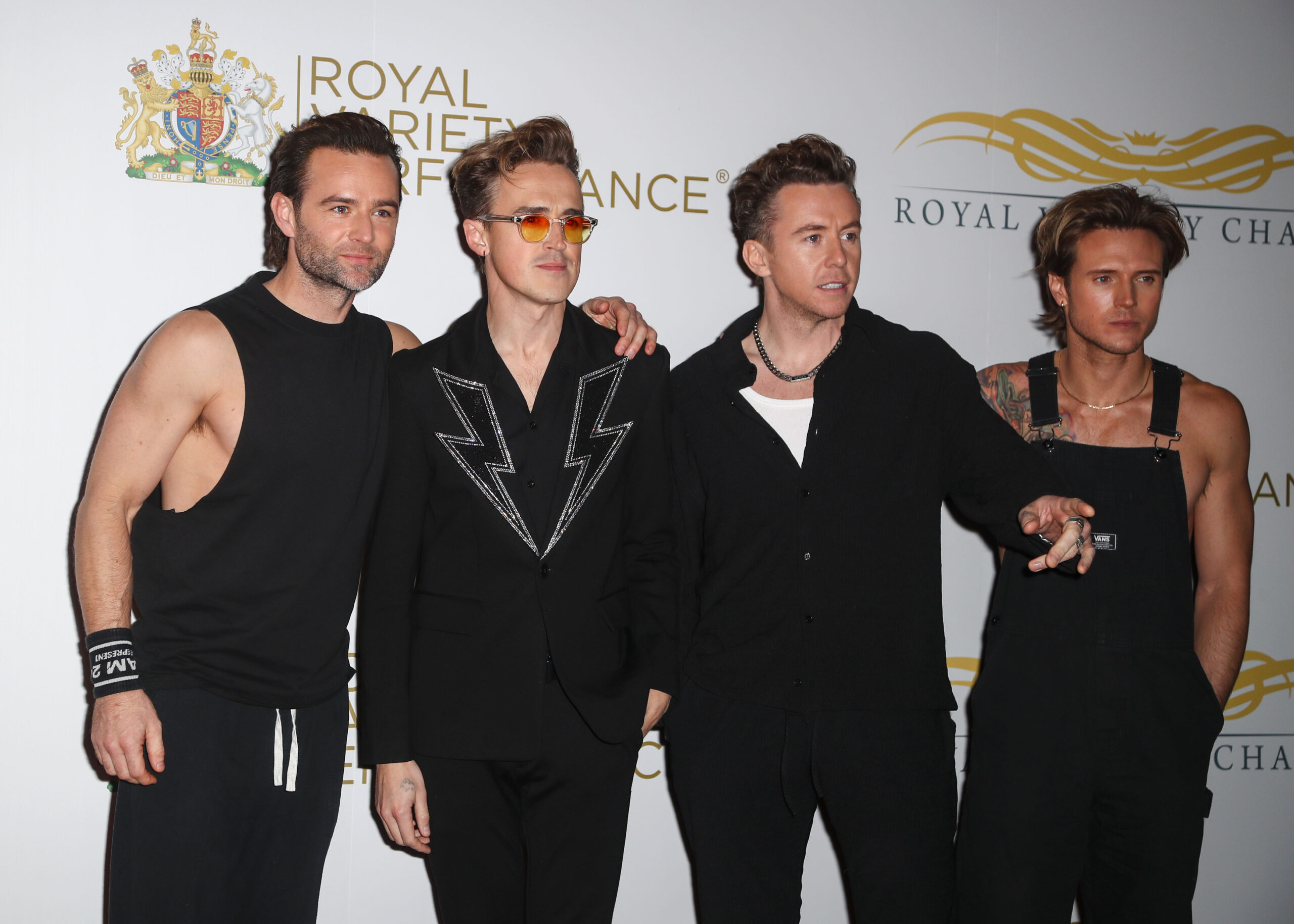 McFly Tom Fletcher, Danny Jones, Dougie Pointer and Harry Judd are all stood in a line wearing black at The Royal Variety Performance 2023