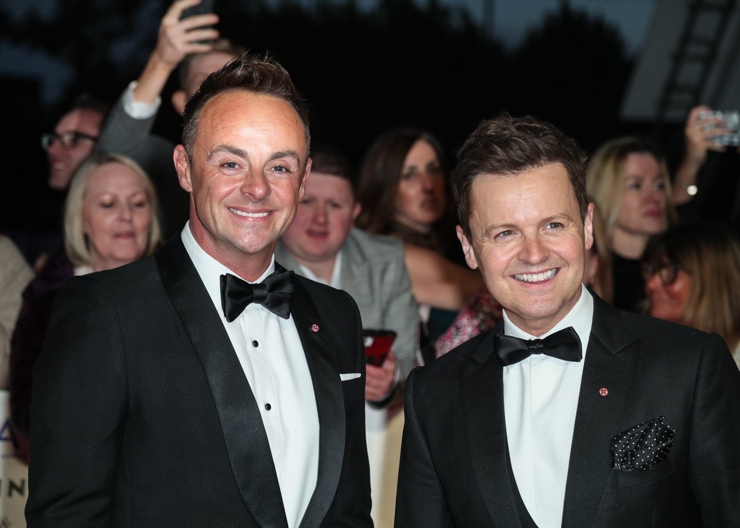 Ant and Dec in black tie at a red carpet event, smiling at the camera