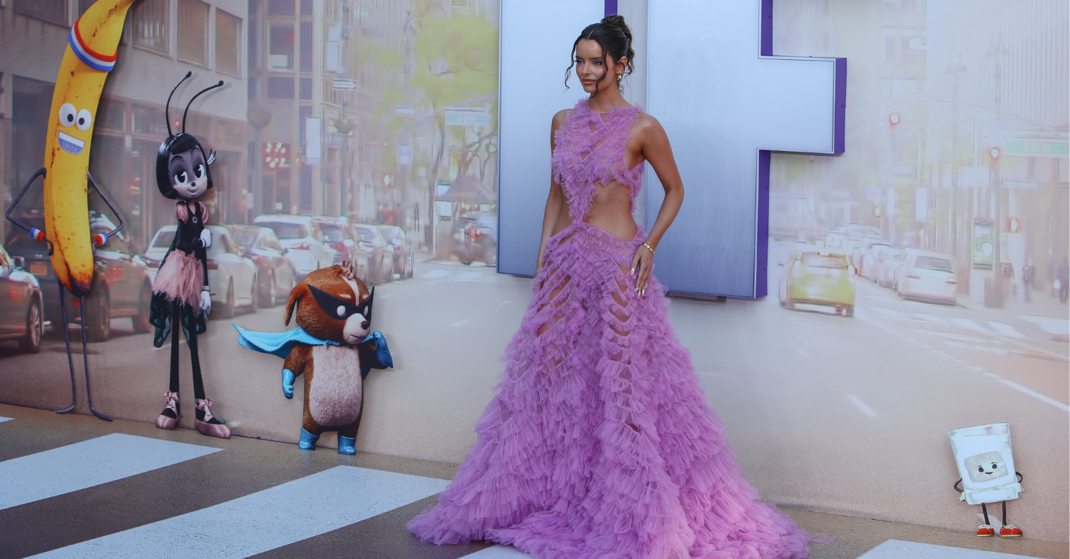 Maura Higgins poses in a pink layered ballgown stood in front of the logo for the animated movie If