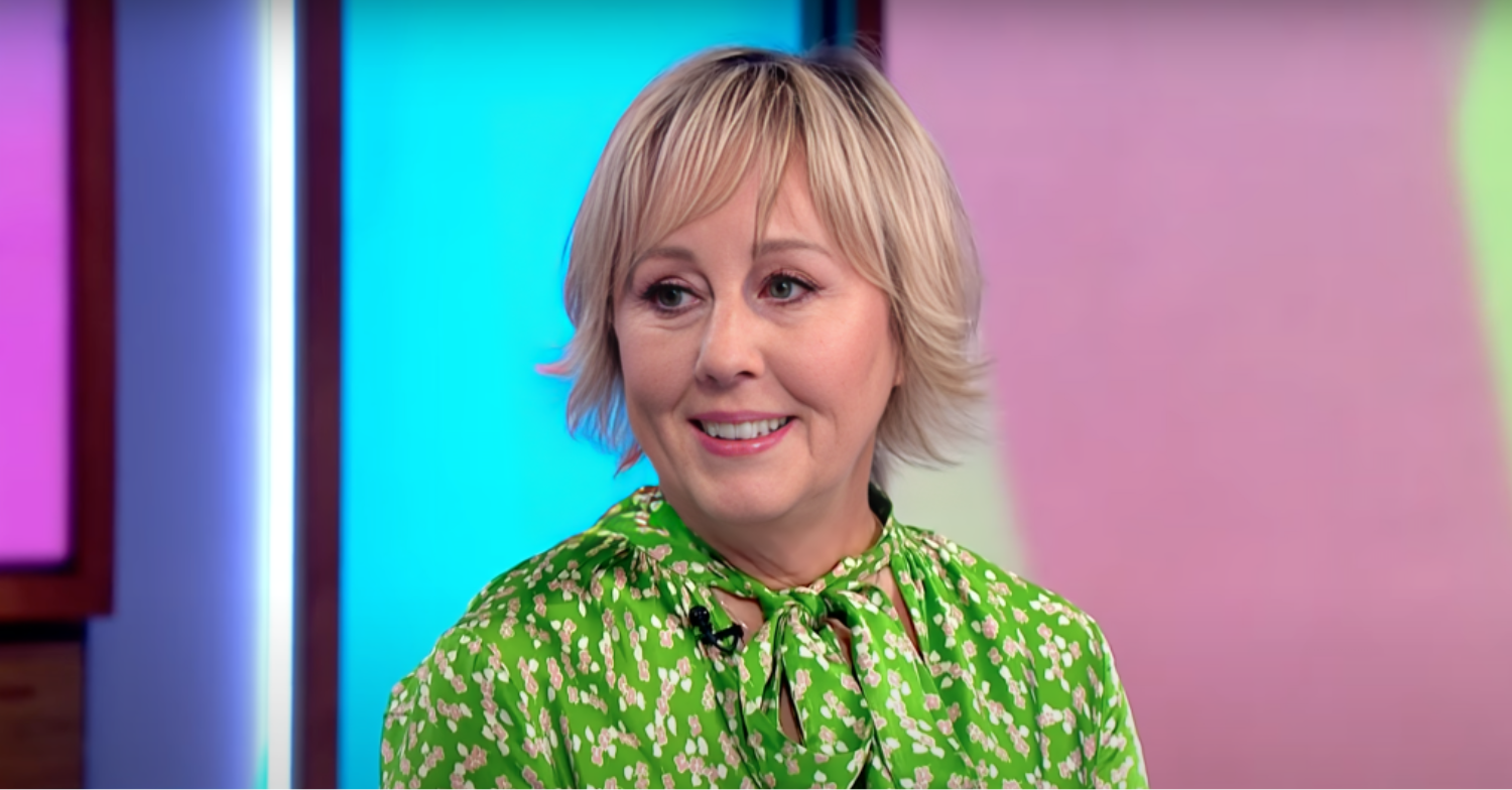 Shirley Kemp has short blonde hair and a green shirt, she is smiling while being interviewed on Loose Women.