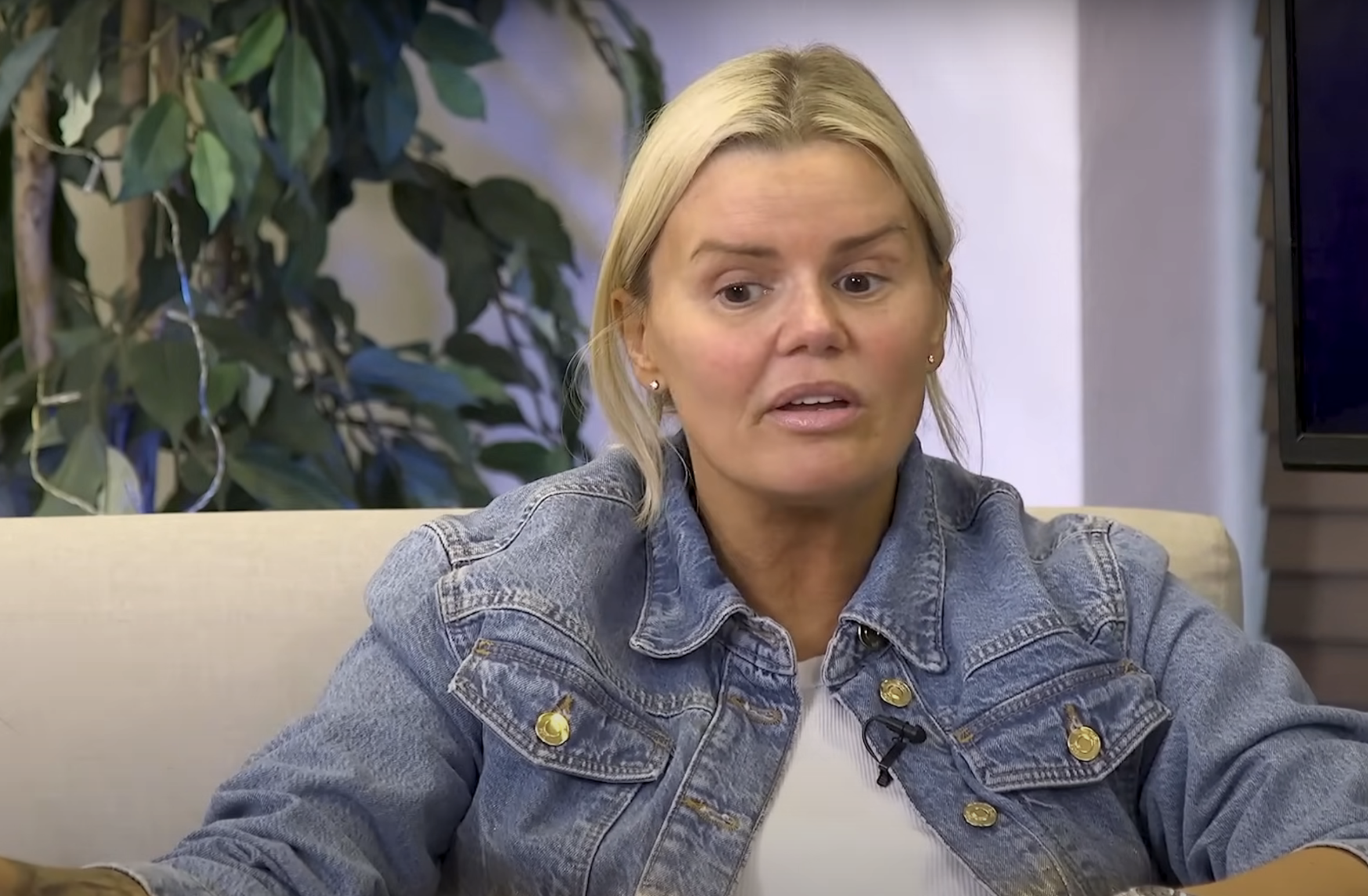 Close up shot of Kerry Katona in a denim jacket sitting on a cream-coloured sofa while being interviewed