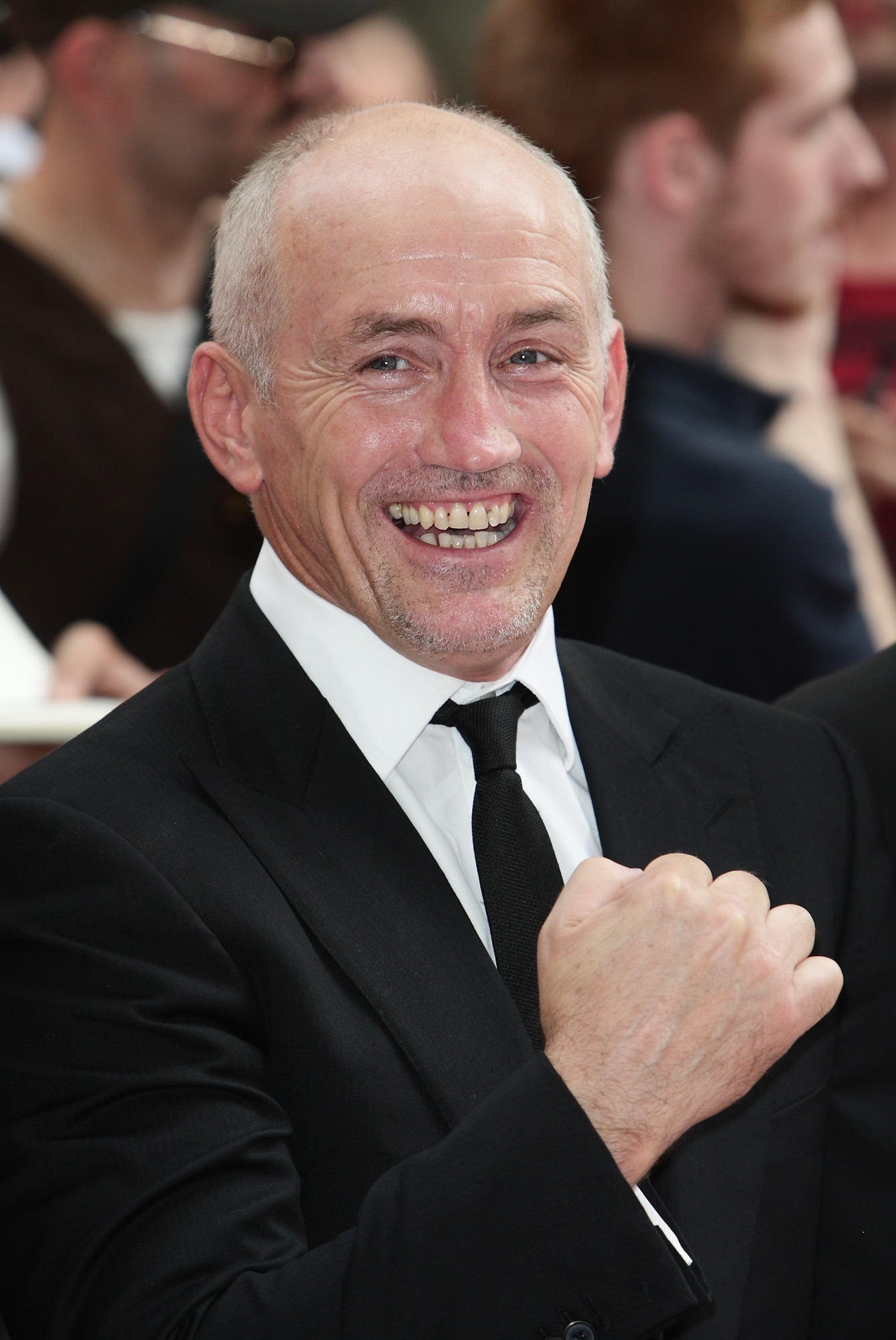Barry McGuigan smiling in a black suit