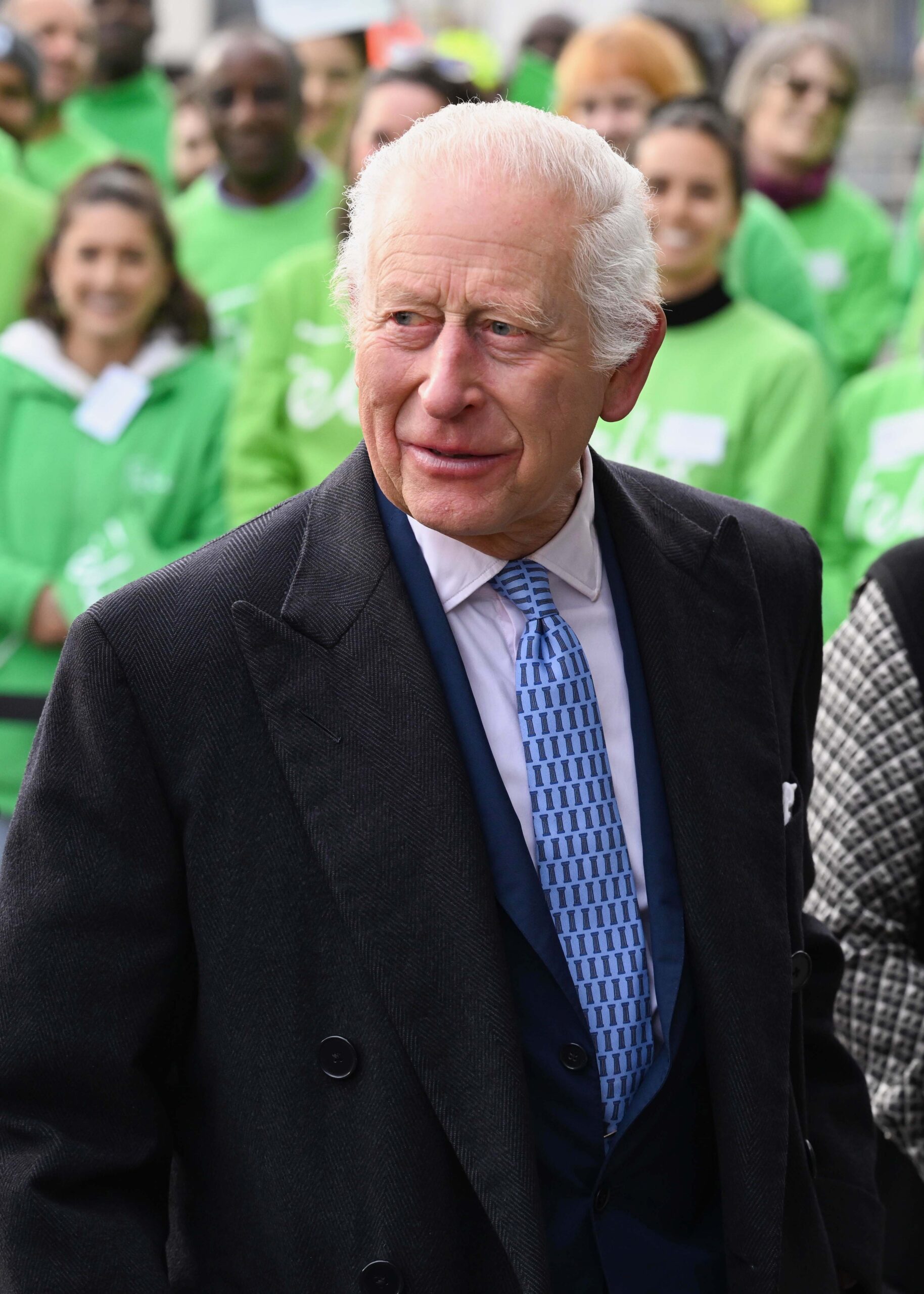 King Charles smiling in black suit