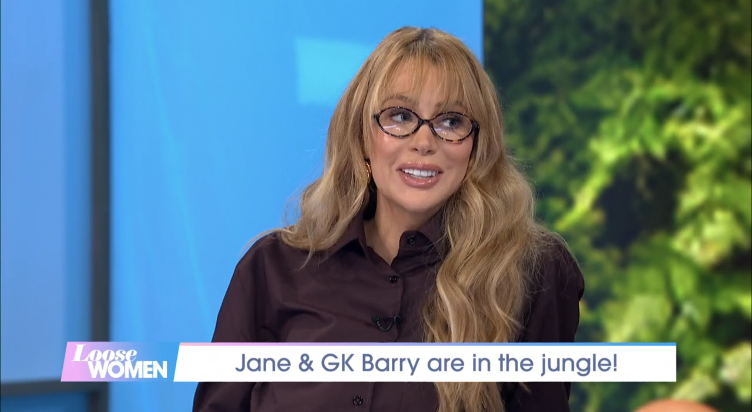 Olivia Attwood in a dark shirt and thick-rimmed glasses, smiling on Loose Women