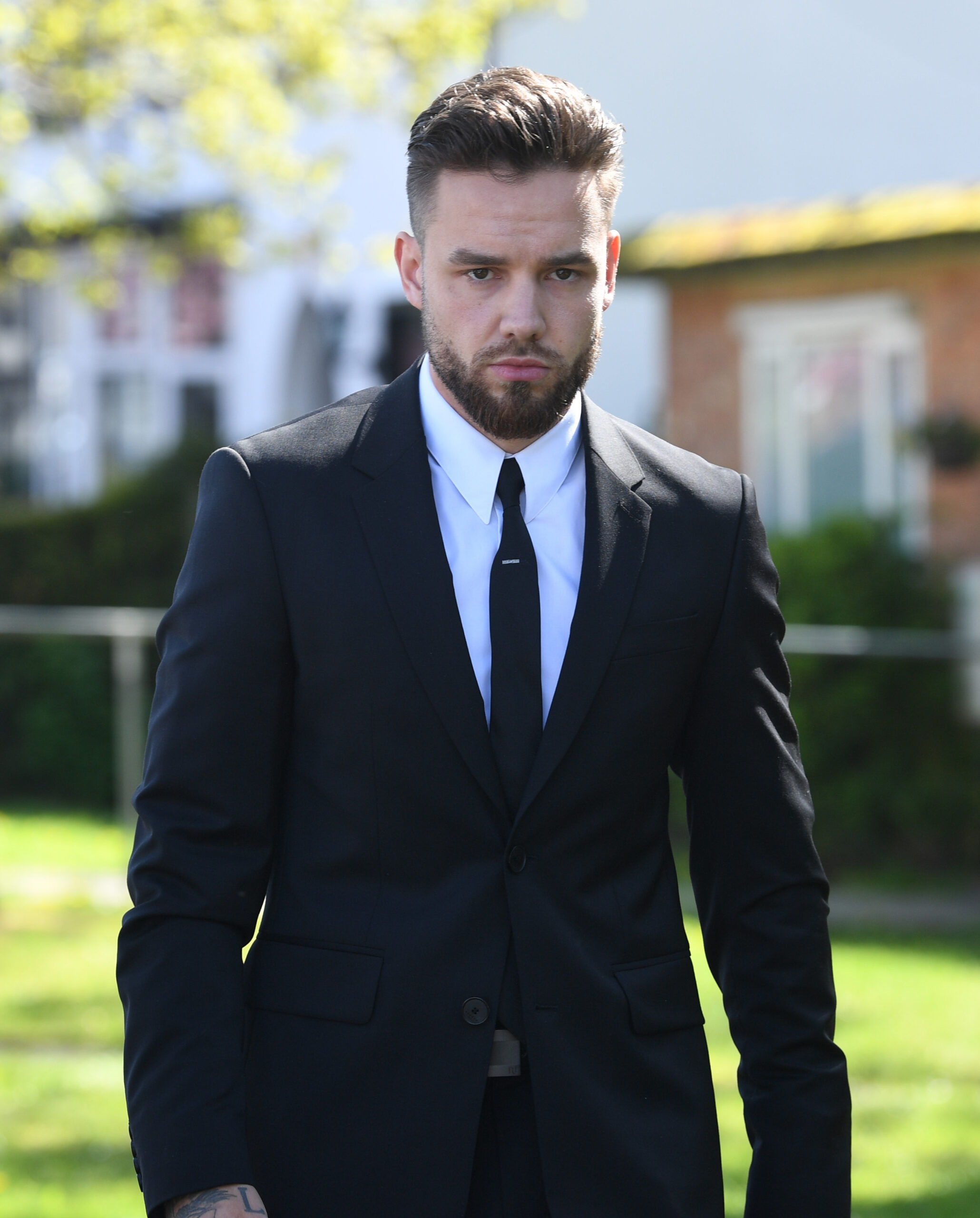 Singer Liam Payne in black suit looking serious