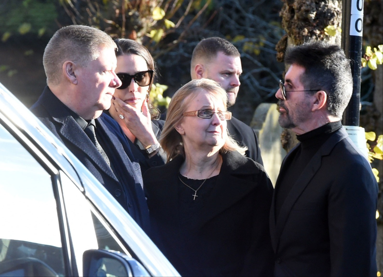 Simon Cowell speaking to Liam Payne's parents at his funeral