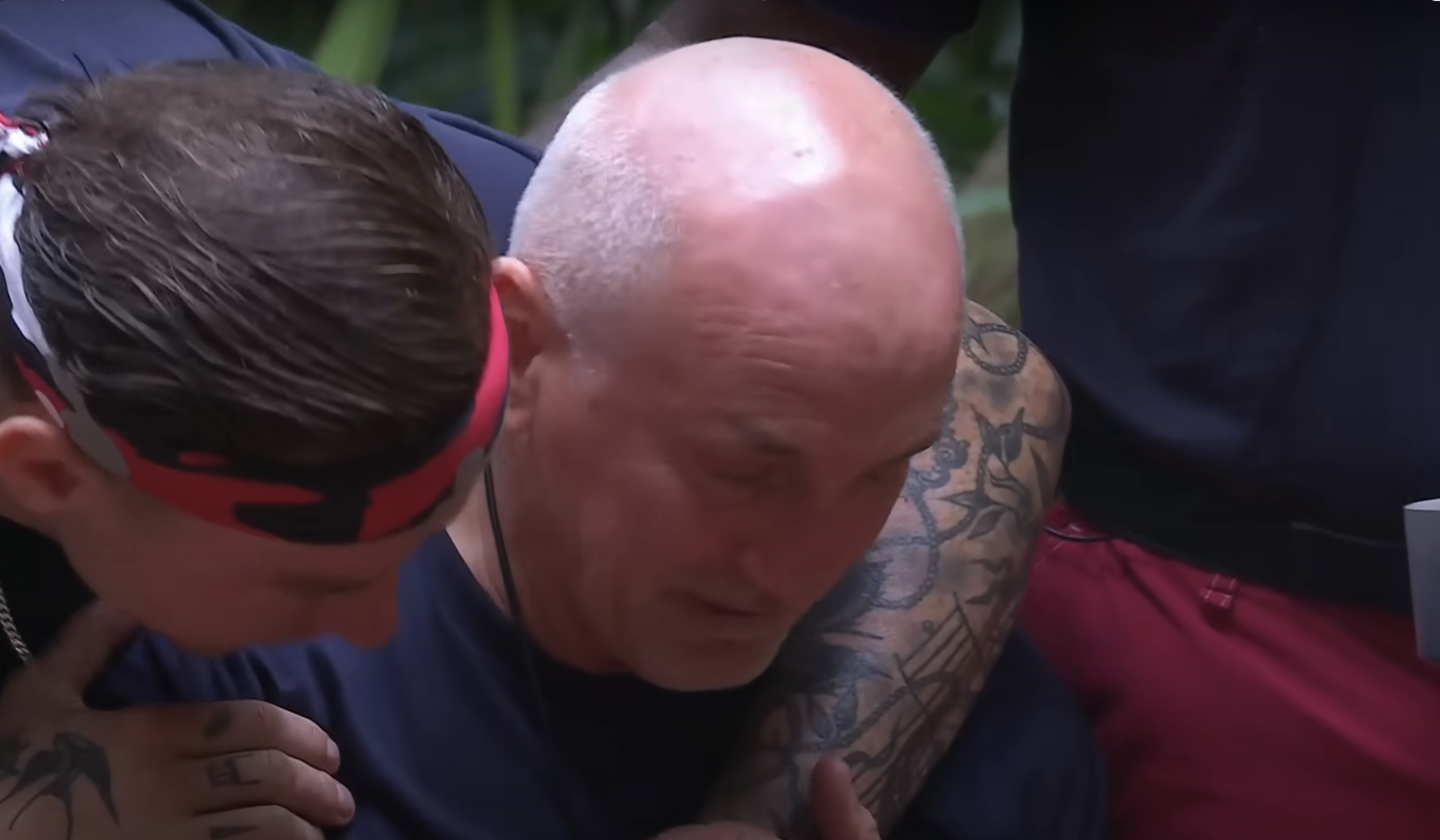 Close up of Barry McGuigan being hugged by a campmate in the I'm A Celebrity jungle