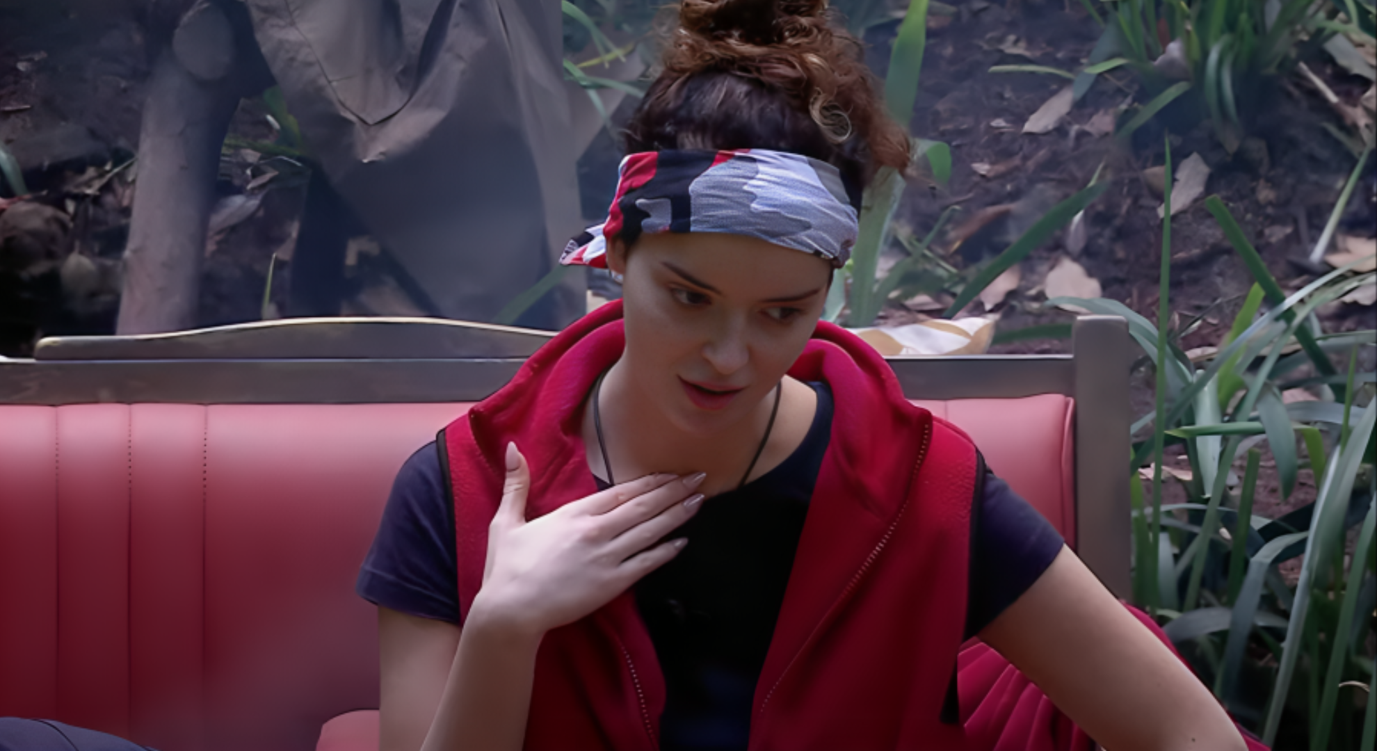 Maura Higgins holds her hand to her neck as she talks to campers in the I'm a Celebrity jungle