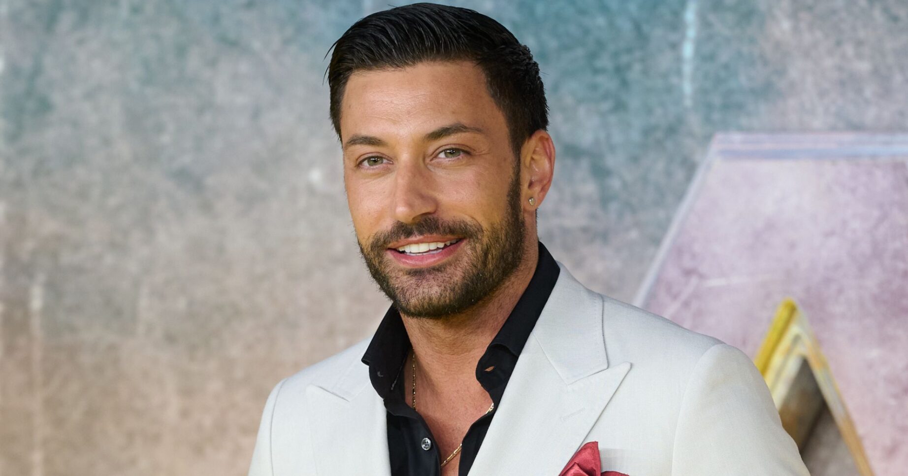 Giovanni Pernice smiling in white blazer at event