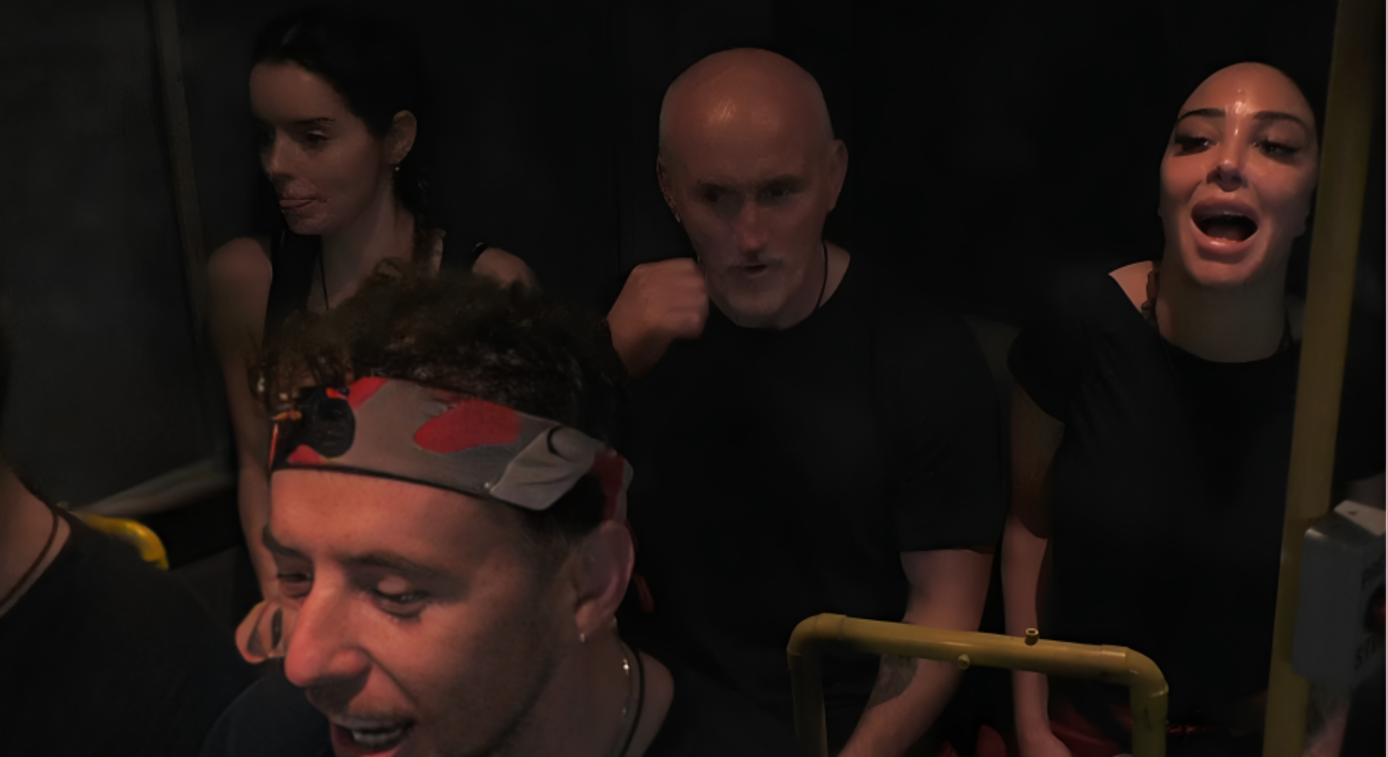 The celebrities are screaming in a low lit shot on the Fright Bus for Maura Higgins' birthday on I'm A Celebrity