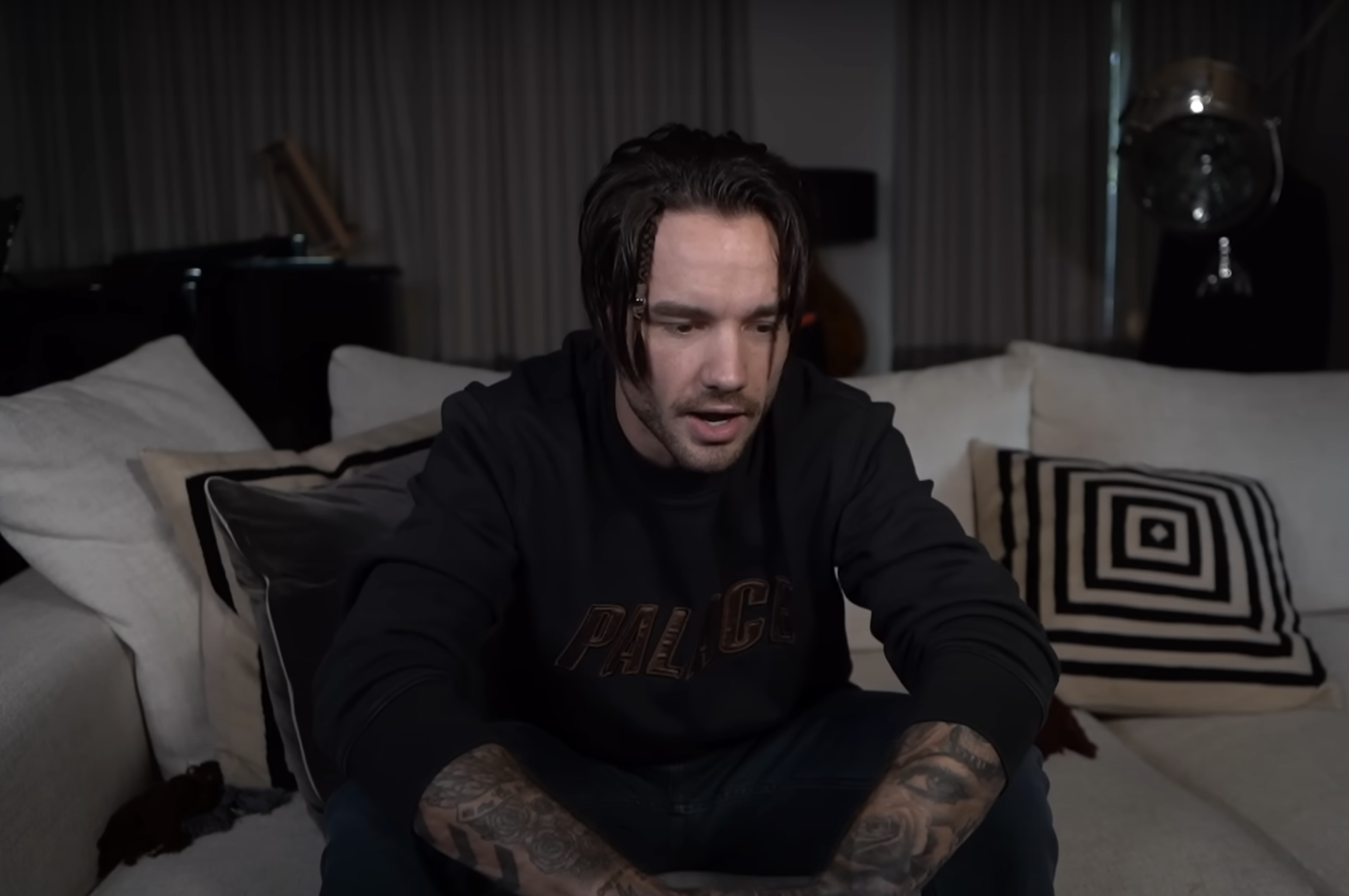 Liam Payne in a black hoody recording a vlog