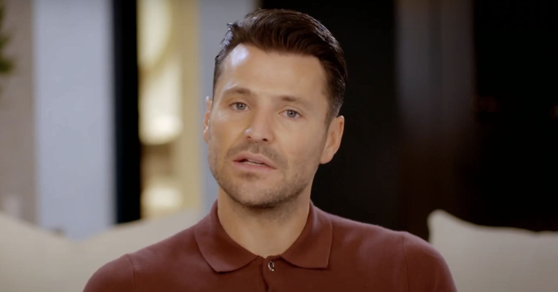 Mark Wright in a brown and patterned polo shirt, sitting on a sofa