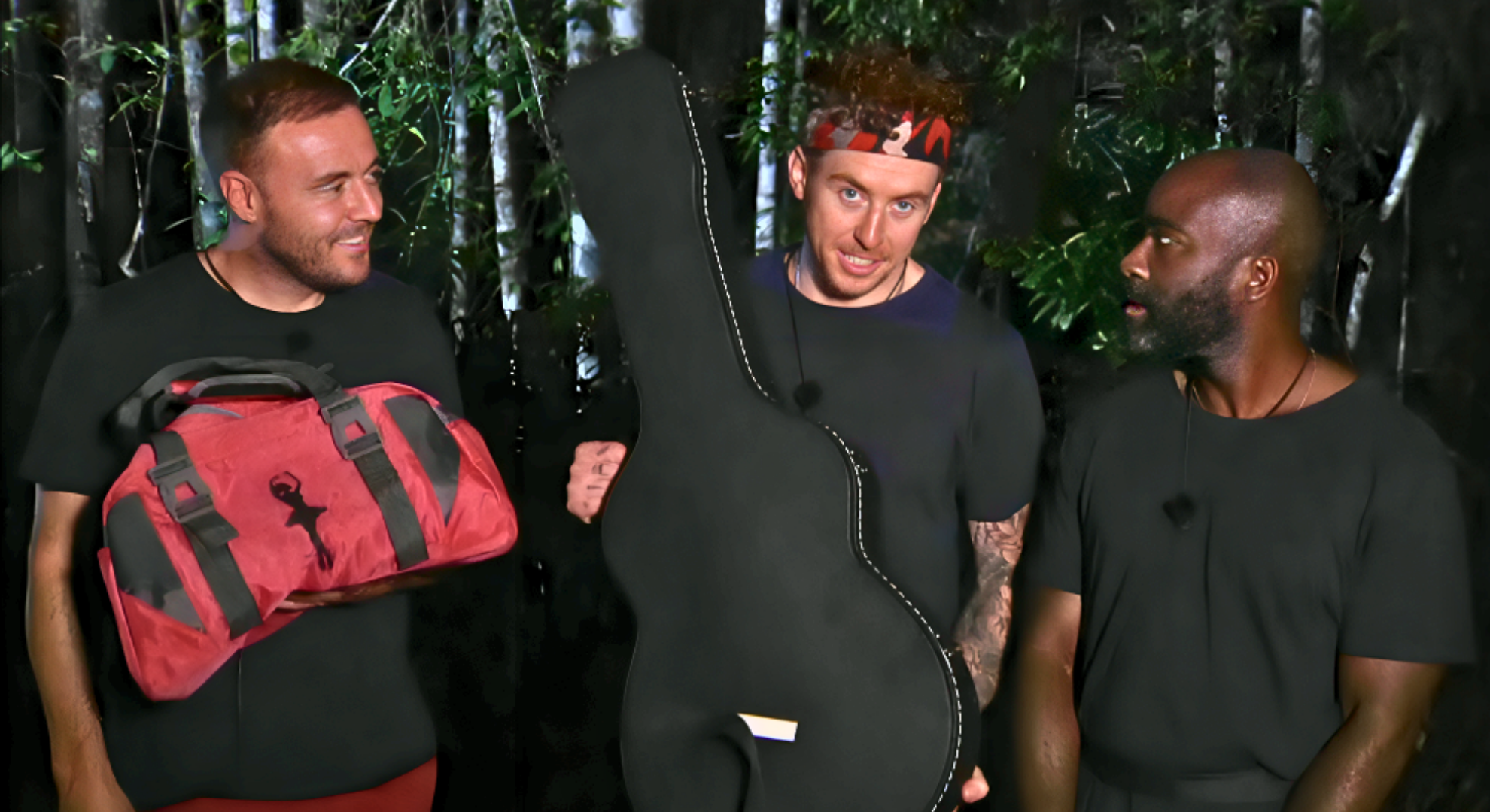 Alan Halsall, Danny Jones and Melvin Odoom stand in a row with the luggage they won from the Fright Bus on I'm A Celebrity