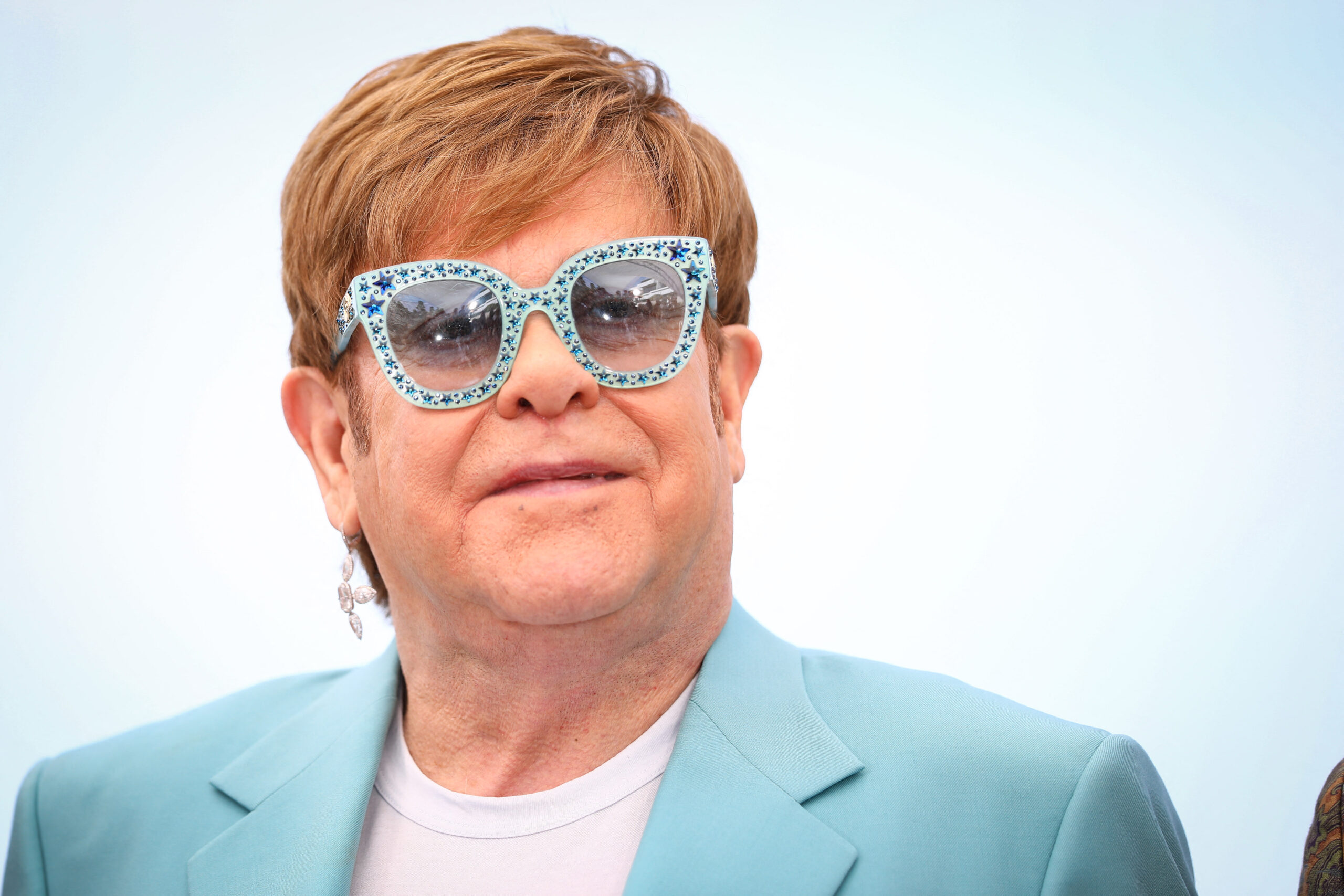 Elton John in customizes glasses and suit at an event