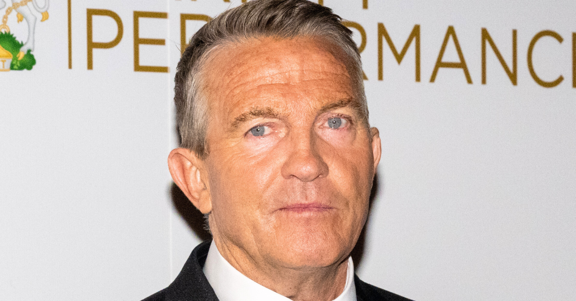 Bradley Walsh looking into the camera dressed in a black suit