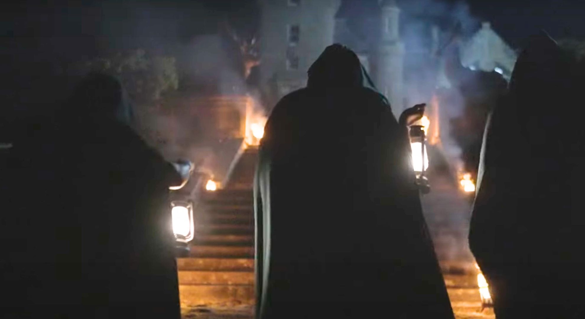 Still from The Traitors series 3 teaser trailer of a hooded person walking up an outdoor staircase