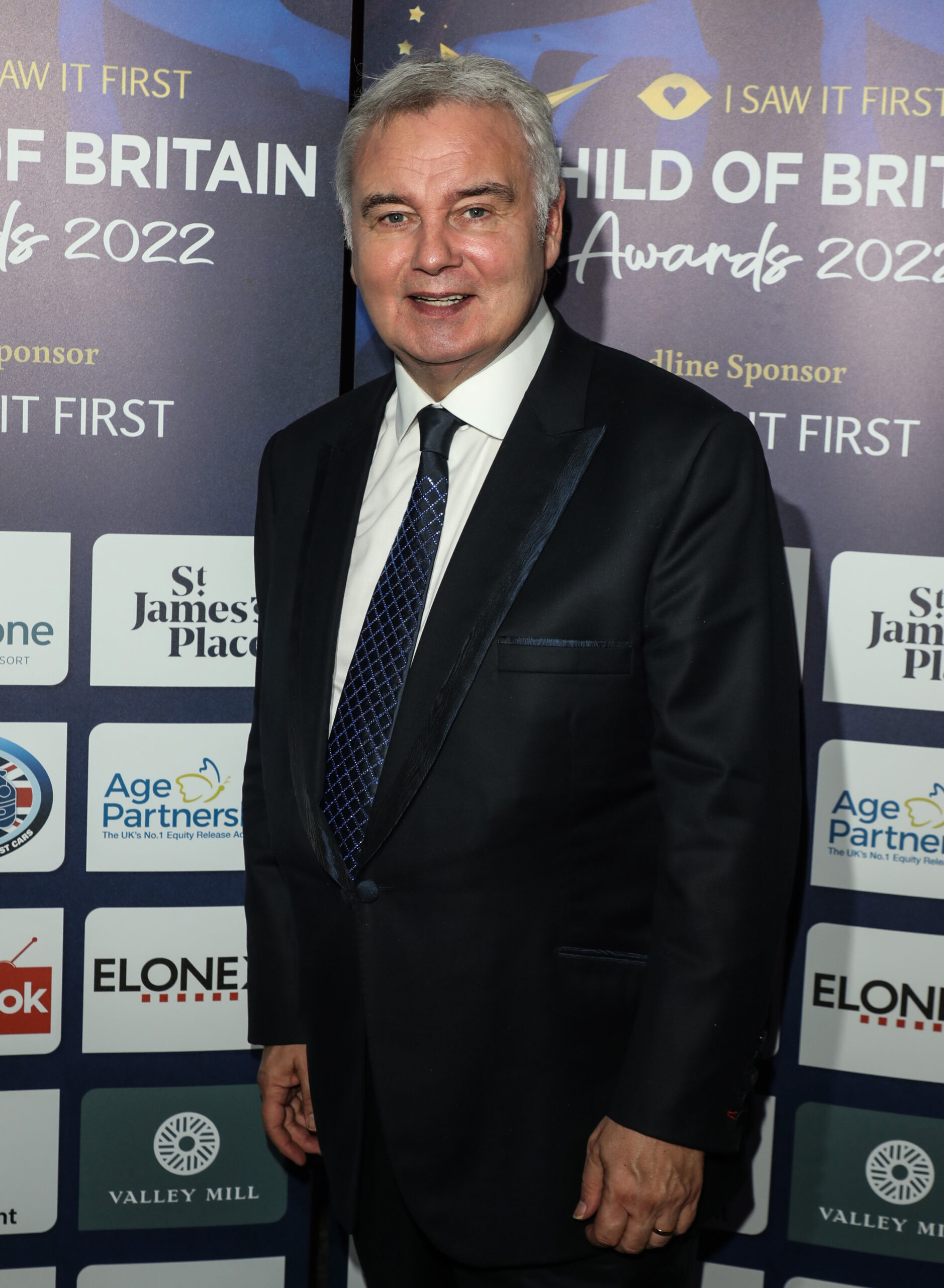Eamonn Holmes smiling in black suit at event