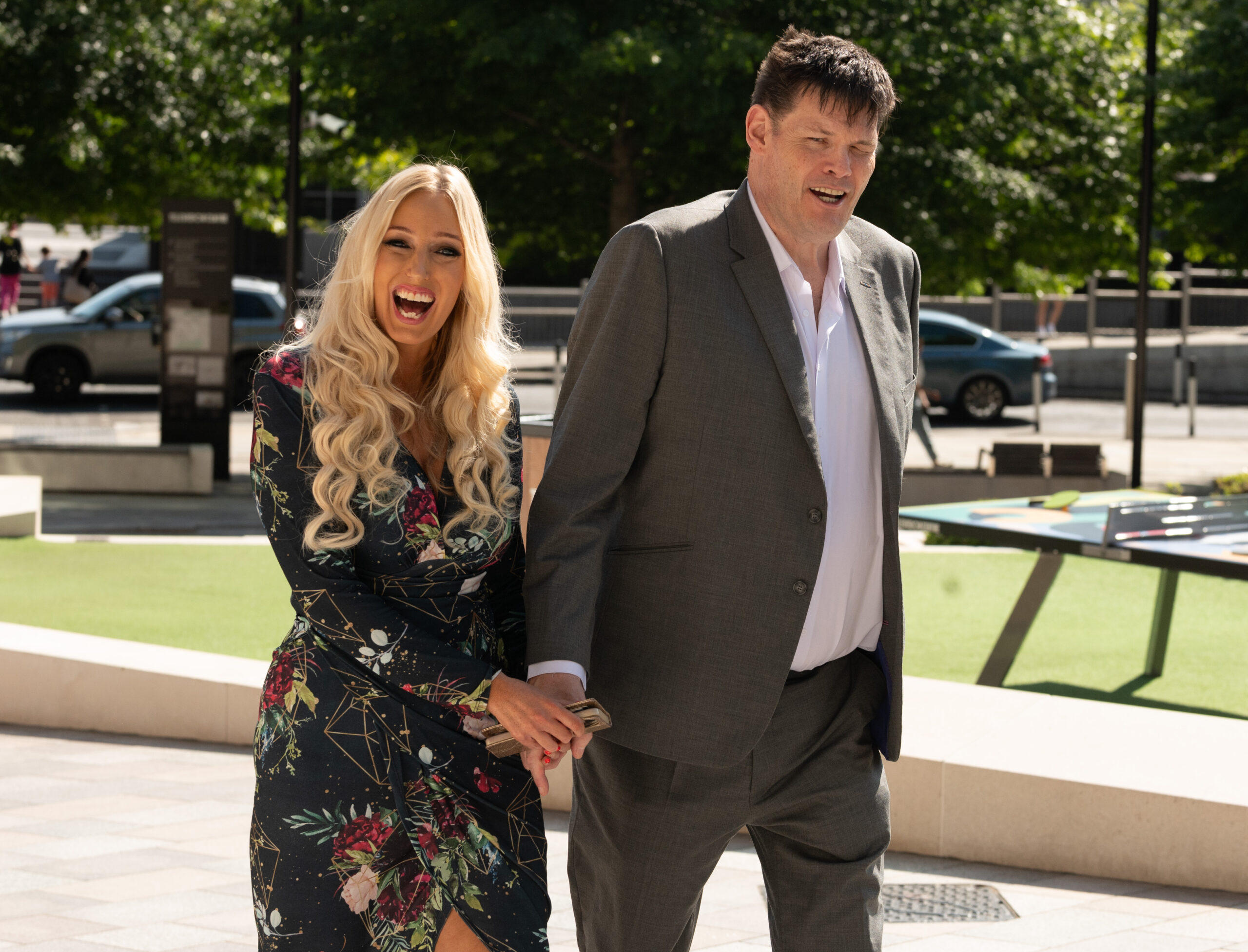 Hayley Palmer smiles as she and Mark Labbett walk hand in hand 