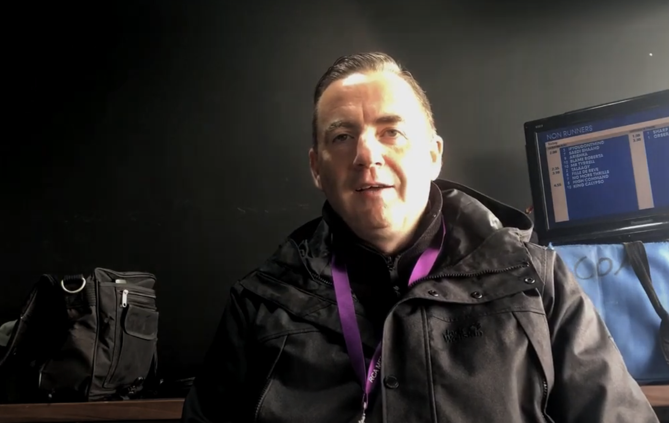 John Hunt in a black raincoat with the sun shining on one half of his face