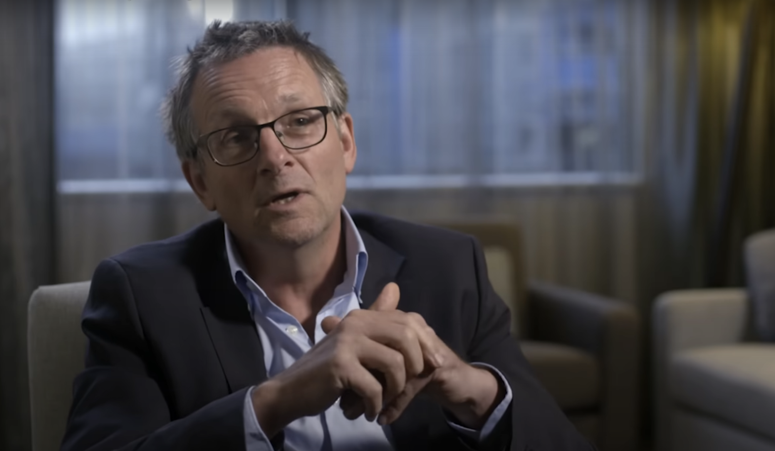 Michael Mosley in a suit during an interview for a podcast