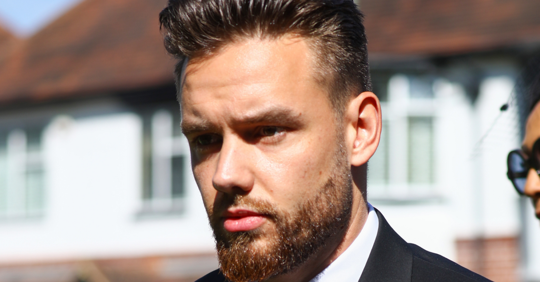 Liam Payne looking stern in a black suit