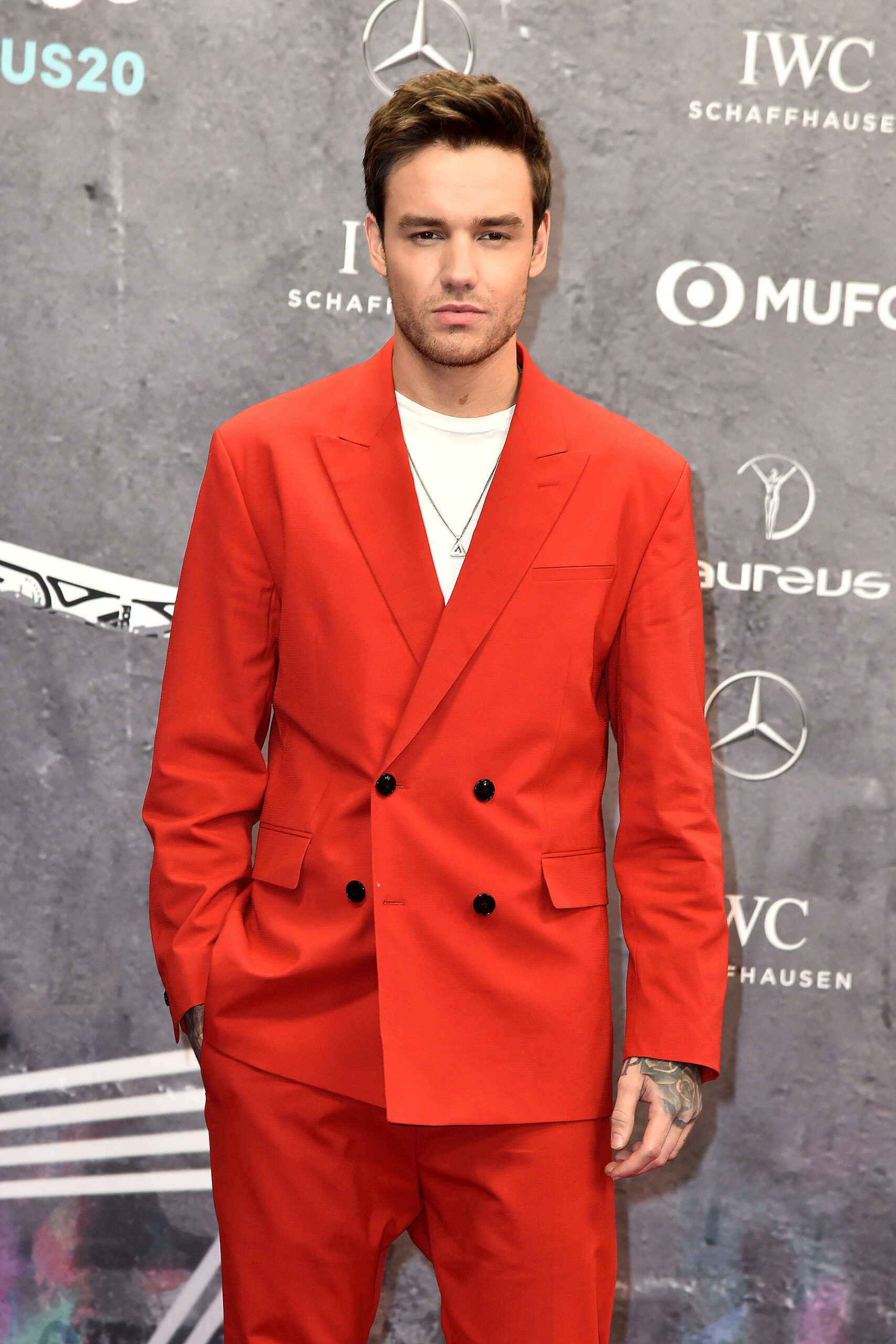 Liam Payne wearing a bright red suit on the red carpet