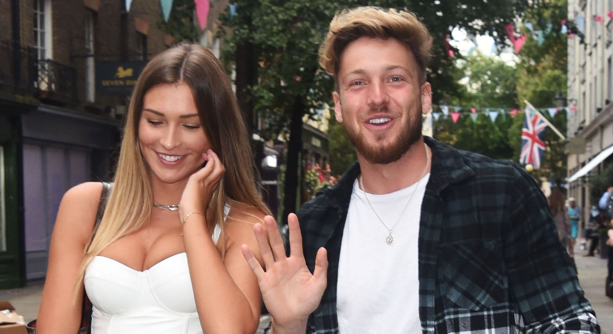 Zara McDermott and Sam Thompson walking together and smiling 