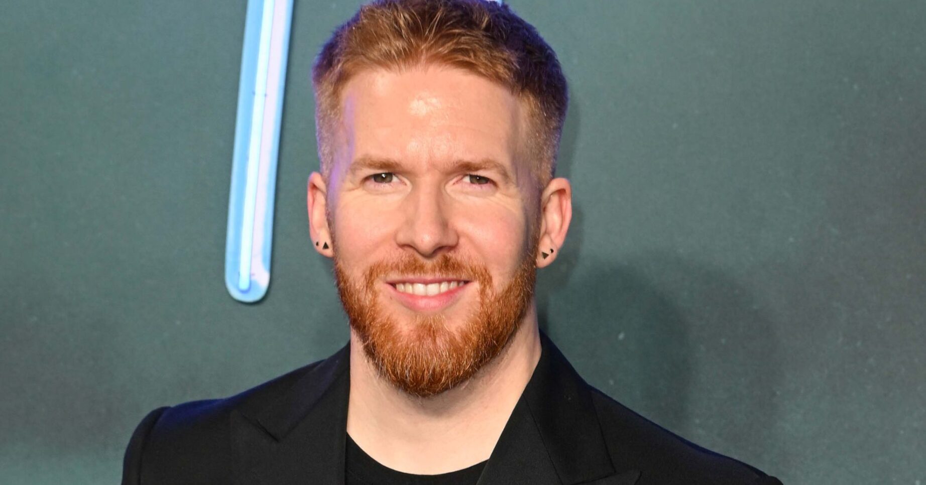 Neil Jones smiles for the camera at 'Road House' Premiere In London