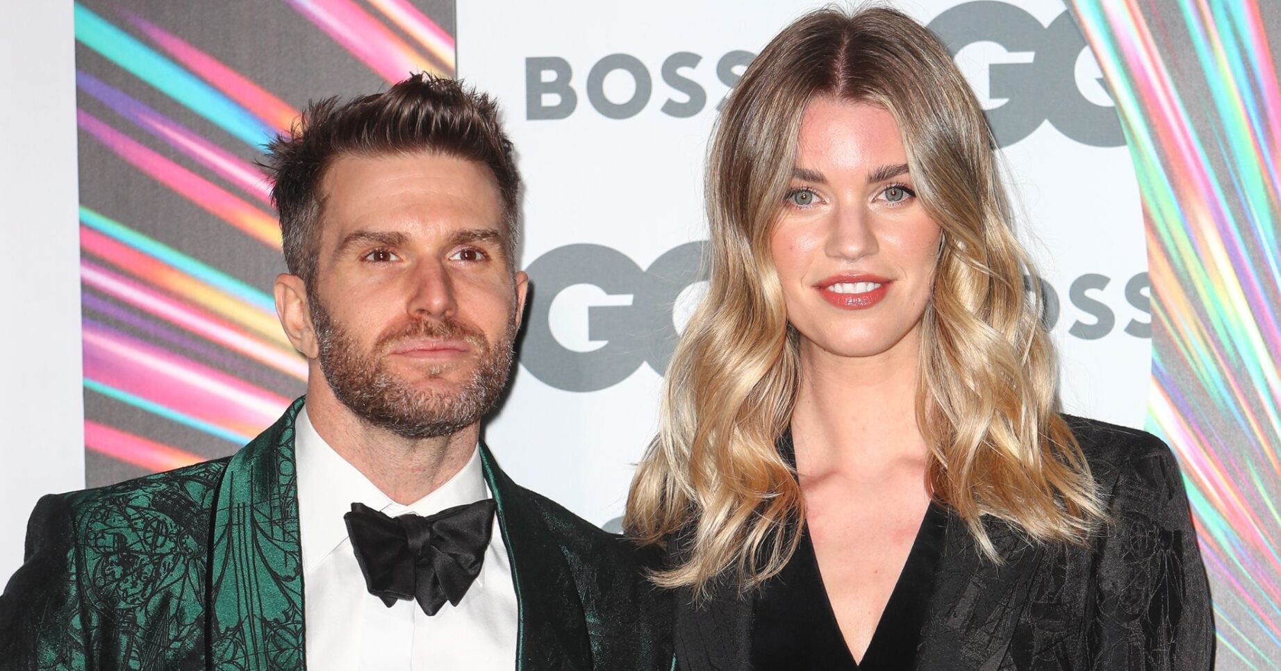 Joel Dommett and Hannah Cooper smile on the red carpet