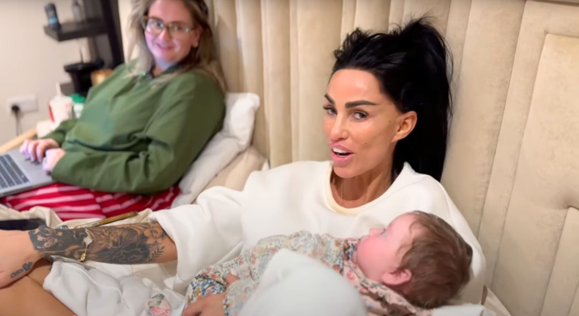 Katie Price looking at the camera holding her sister's baby 