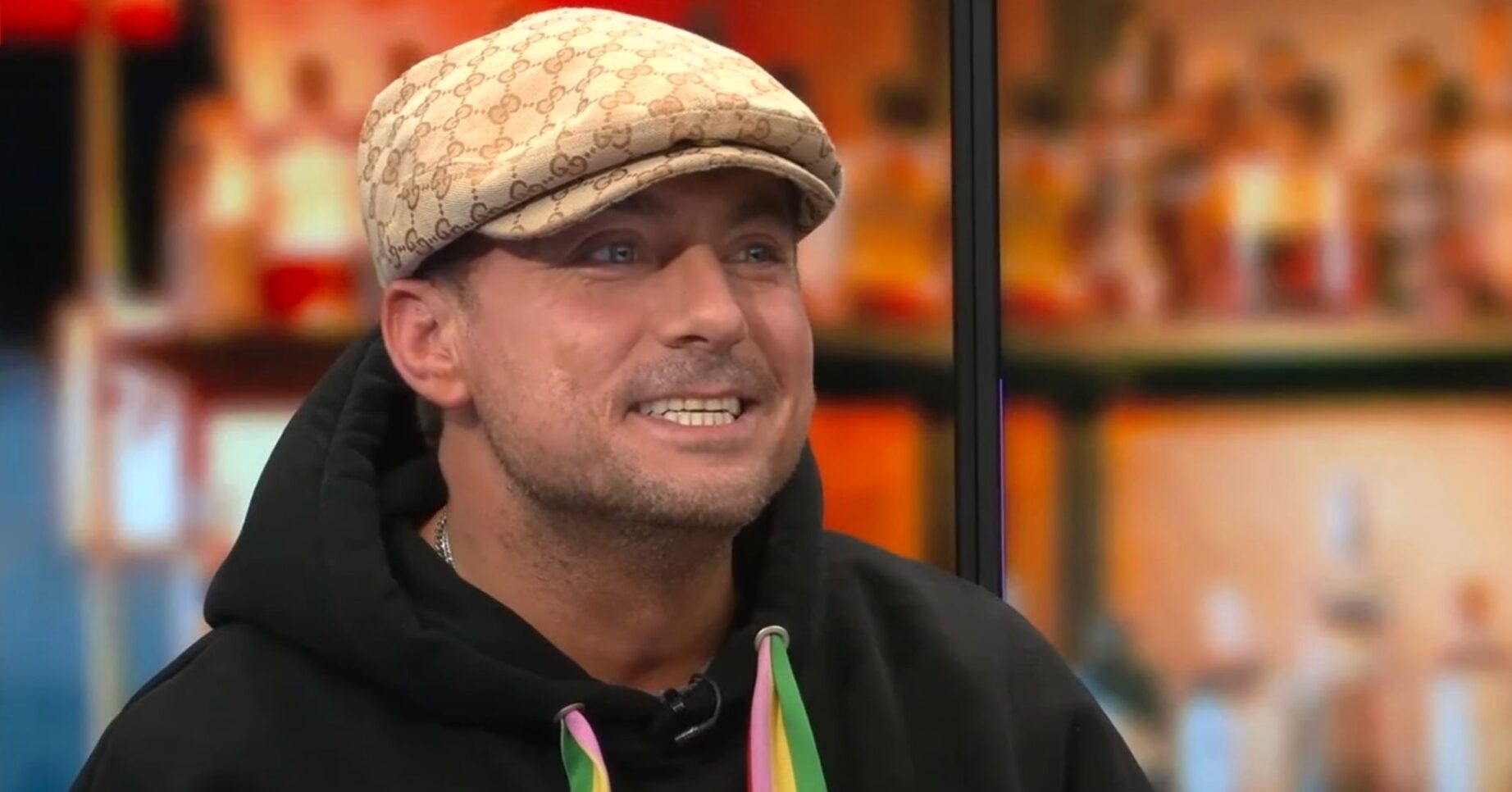 Paul Danan smiling wearing a cap