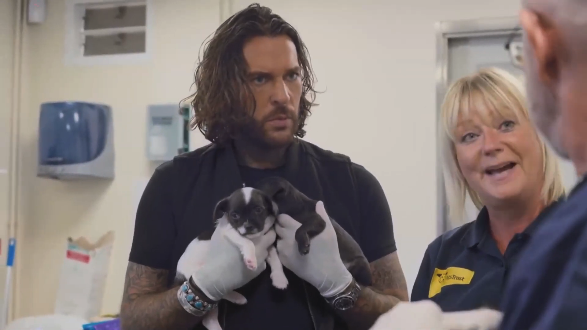 Pete Wicks holding two puppies