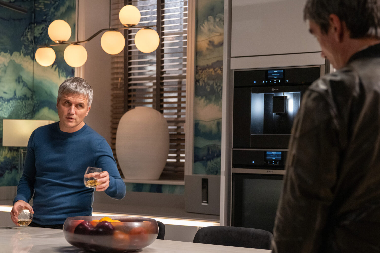 Caleb offering Cain a drink in Emmerdale