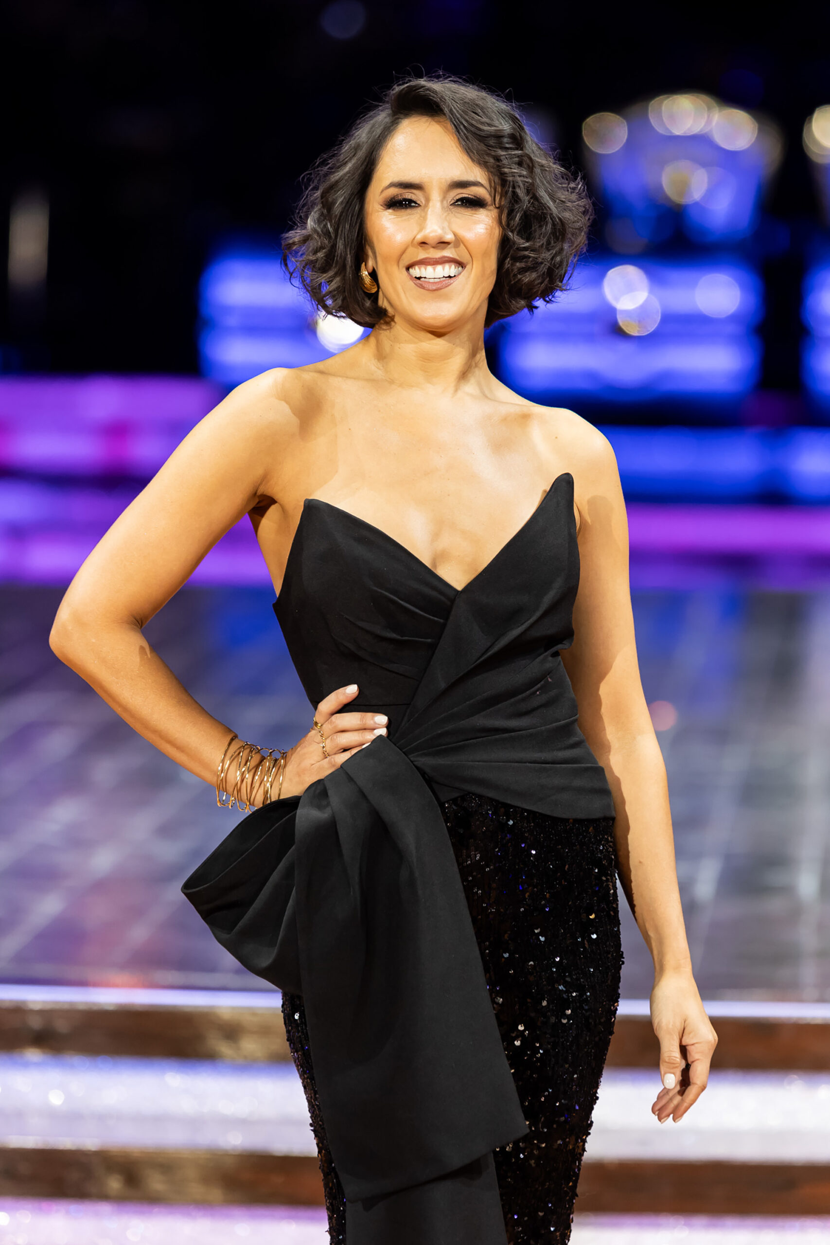 Janette Manara smiling in a posing in a black dress 