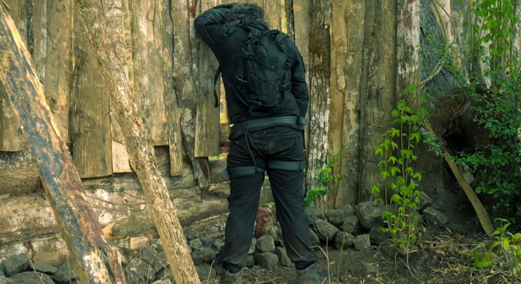 Laurence Llewelyn-bowen weeing against a fence