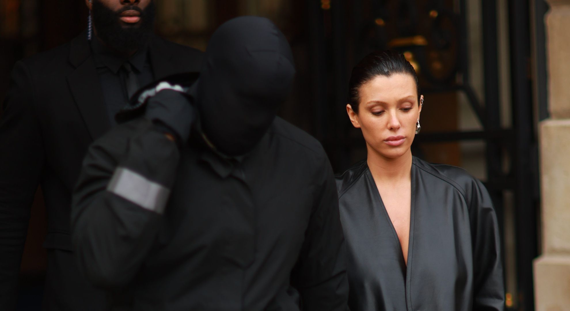 Kanye West covering his face beside Bianca Censori