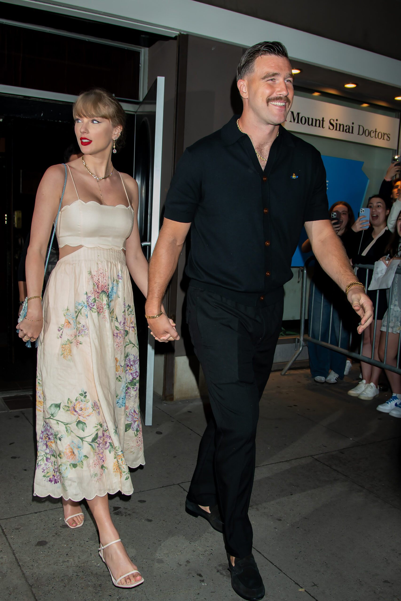 Taylor Swift and Travis Kelce walking hand in hand 