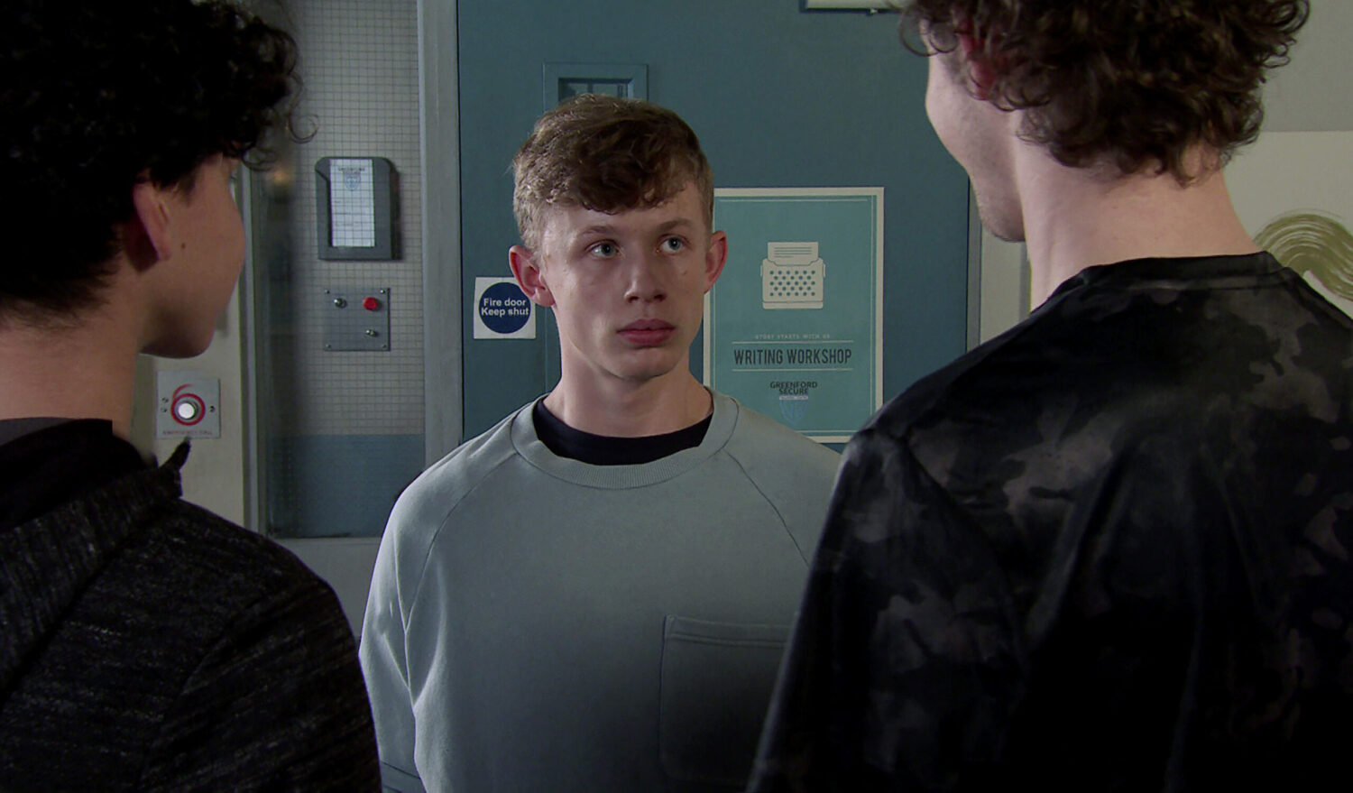 Dylan surrounded by two lads at the STC in Coronation Street