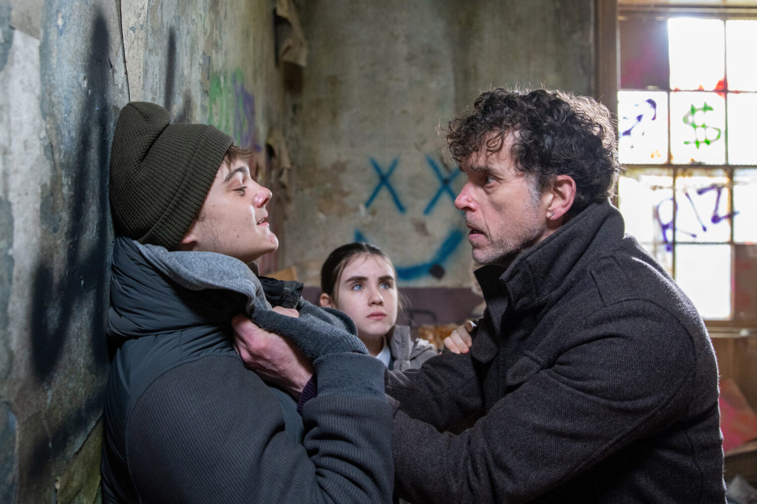 Marlon pinning Dylan up against a wall